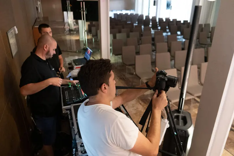 Víctor trabajando con cámara en una producción audiovisual interior