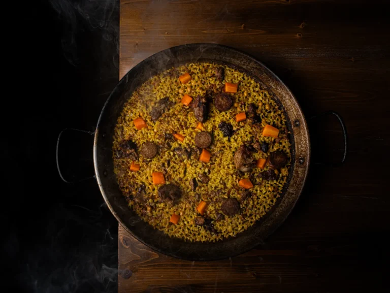 Paella presentada sobre una mesa de madera