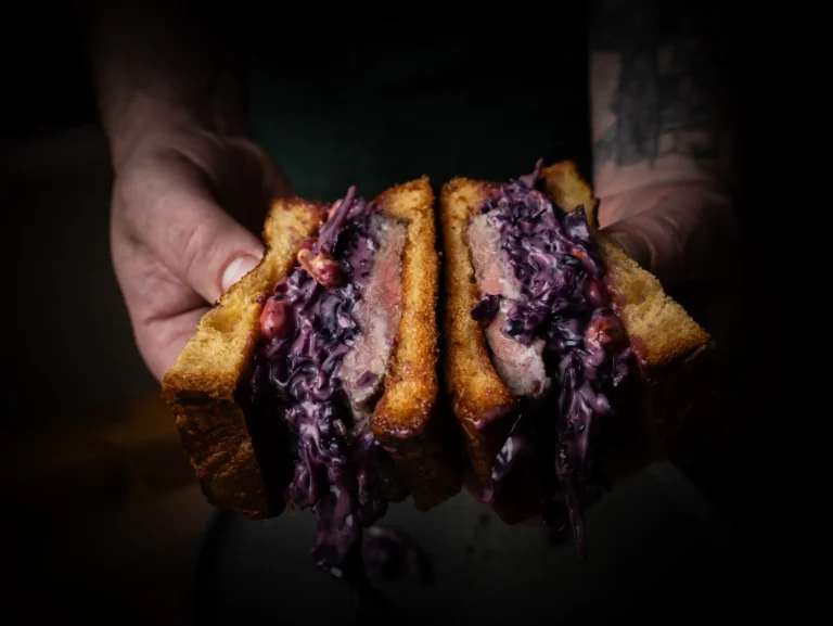 Sándwich abierto sostenido entre unas manos