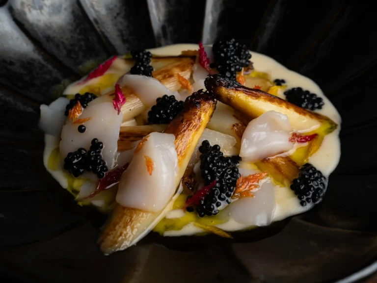 Elaboración de pescado, crema y caviar en primer plano