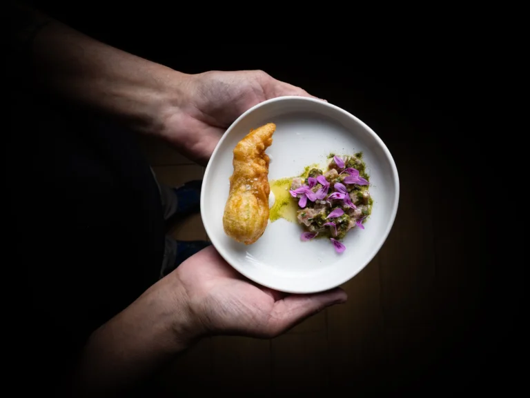 Pequeño plato gastronómico sostenido entre unas manos