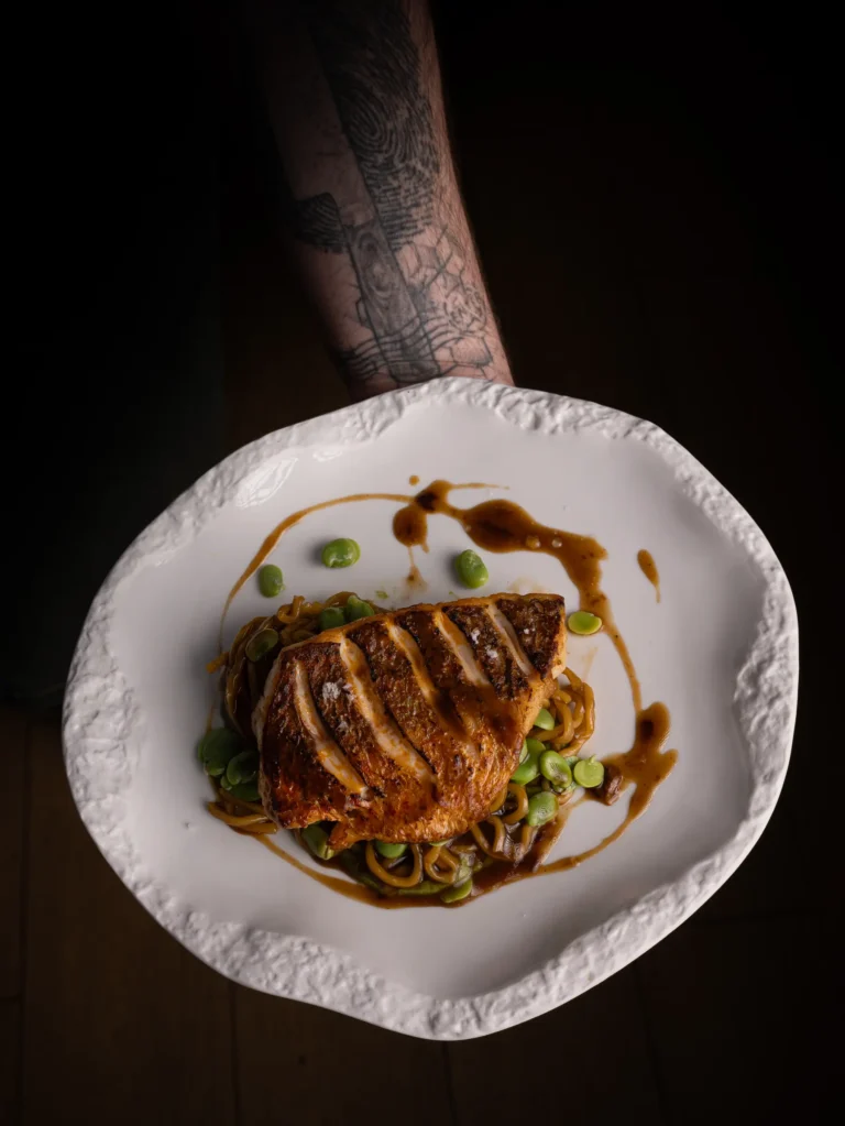 Mano sosteniendo un plato de cocina contemporánea