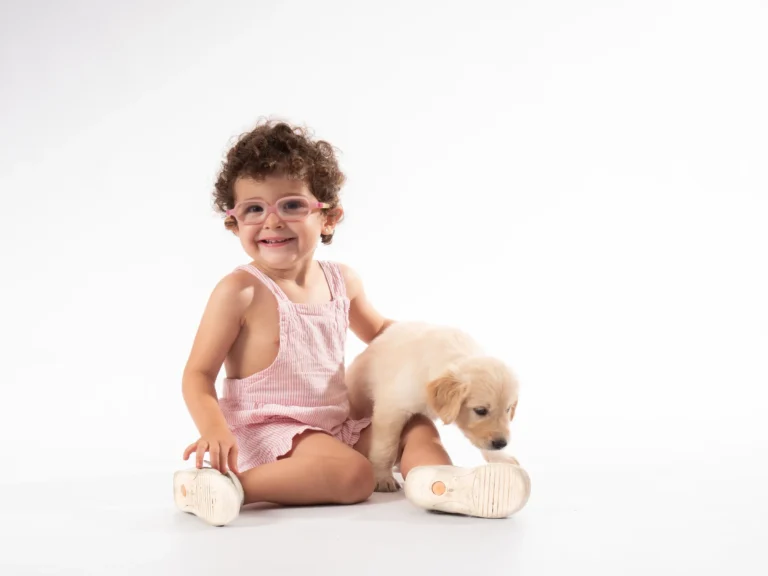 Niña sentada con un peluche sobre fondo blanco