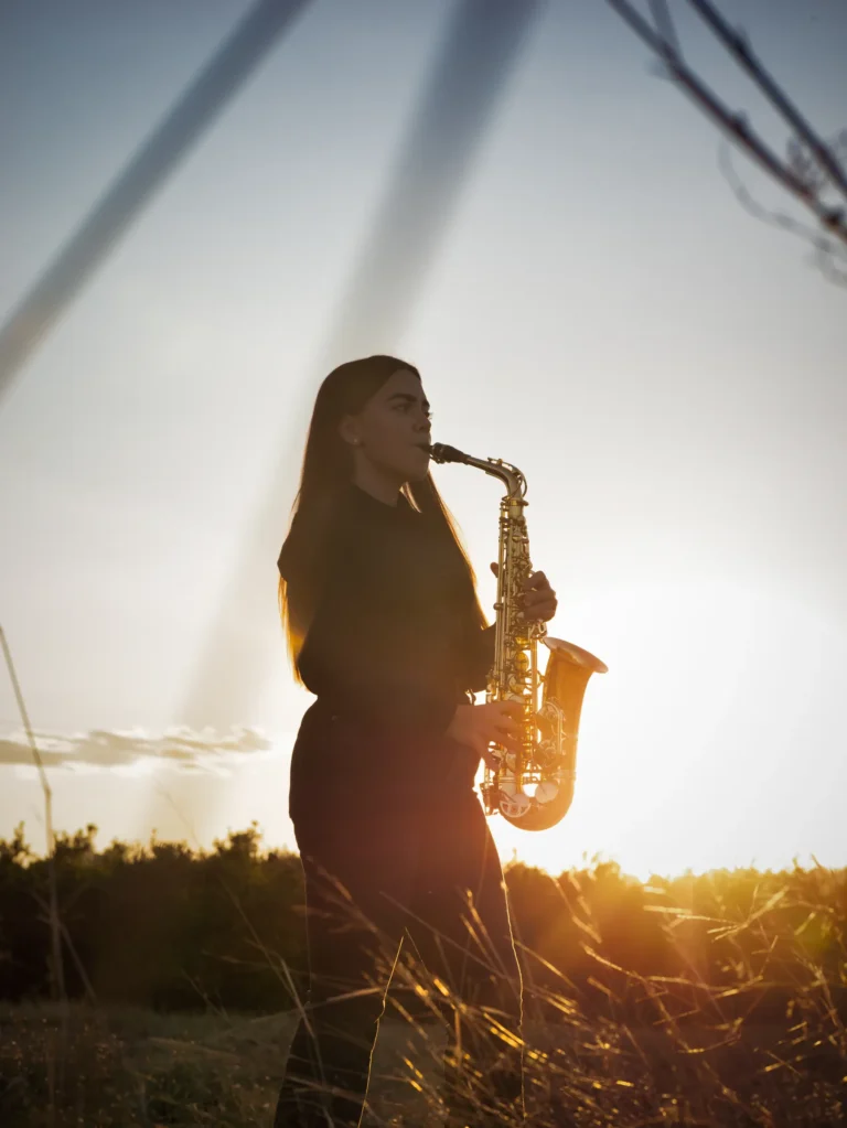 Músico tocando el saxofón a contraluz al atardecer