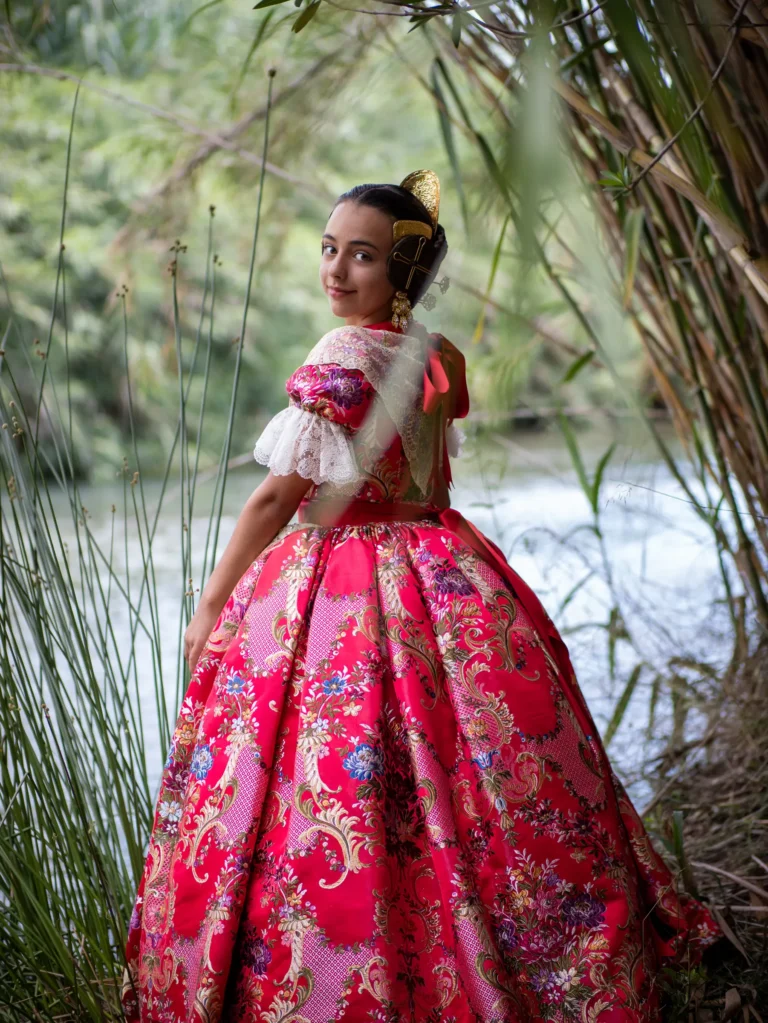 Mujer con indumentaria tradicional valenciana en un paisaje de palmeras