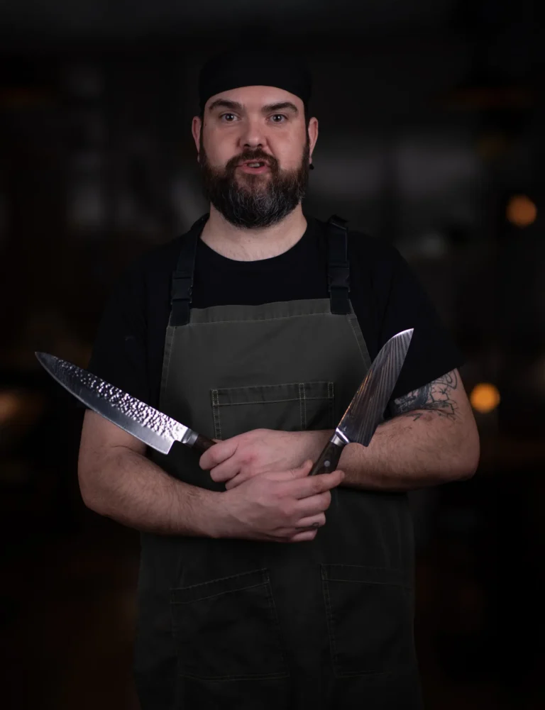 Retrato de un cocinero sosteniendo sus cuchillos