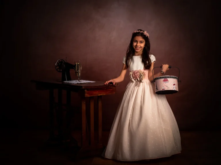 Niña con una máquina de coser y una cesta en estudio