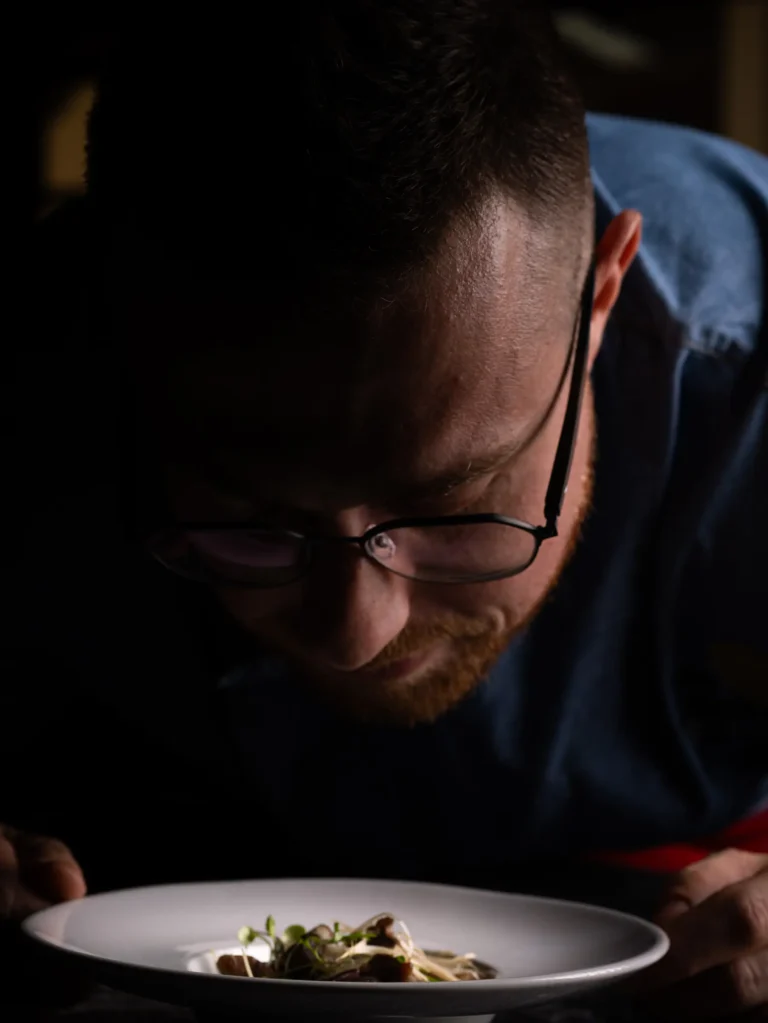 Primer plano de un cocinero trabajando con un plato