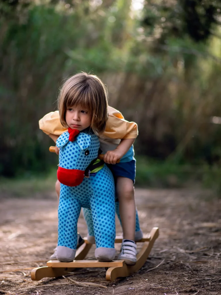 Niño abrazando un juguete tejido en el bosque