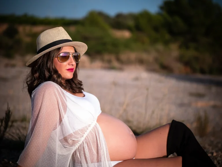 Mujer embarazada con sombrero en un paisaje natural