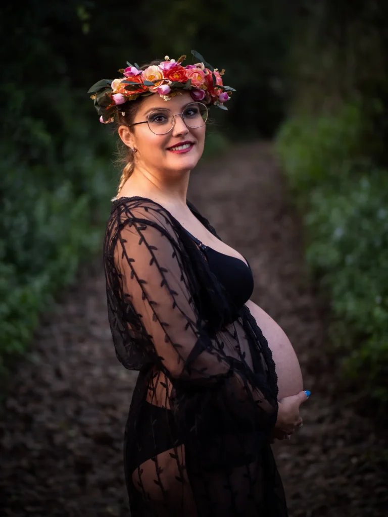 Mujer embarazada con corona de flores en un entorno natural