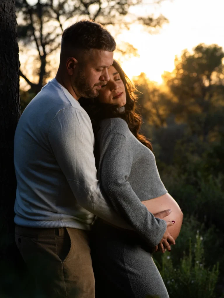 Pareja durante una sesión de embarazo al atardecer