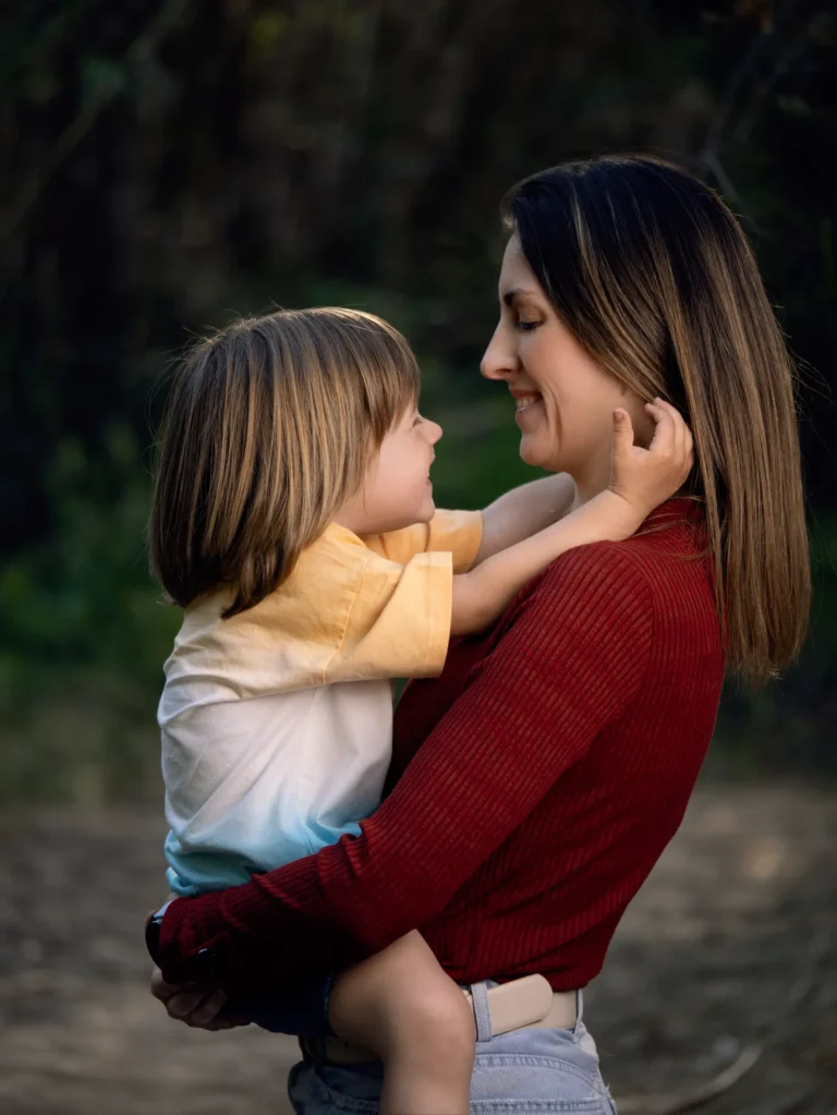 Madre y niño abrazados en un retrato exterior