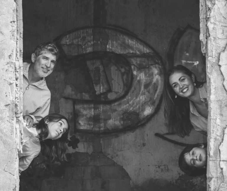 Familia asomándose a una puerta en un retrato en blanco y negro