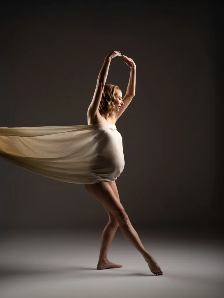 Bailarina con vestido blanco en estudio oscuro